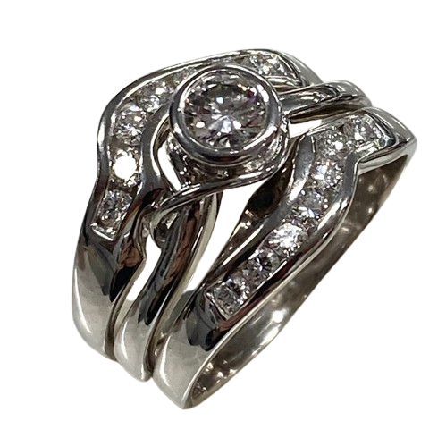 Ladies 18ct White Gold 3 Ring Set. Rub Over Set 0.30ct Round Brilliant Cut Diamond, With 7 Round Brilliant Cut Channel Set In Fitted Bands Each Side. TDW 0.72ct. Size O With Valuation Certificate.