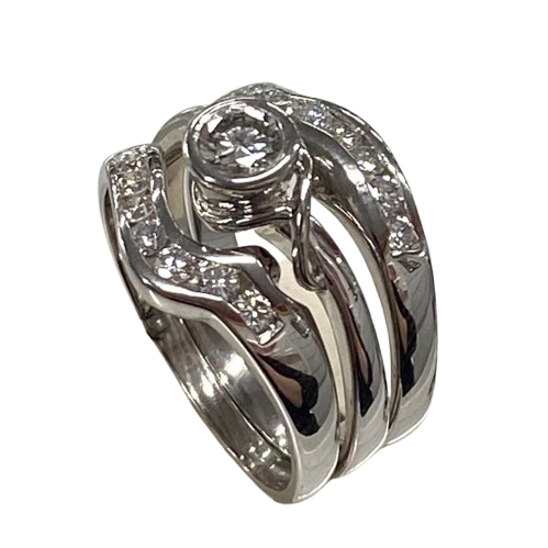 Ladies 18ct White Gold 3 Ring Set. Rub Over Set 0.30ct Round Brilliant Cut Diamond, With 7 Round Brilliant Cut Channel Set In Fitted Bands Each Side. TDW 0.72ct. Size O With Valuation Certificate.