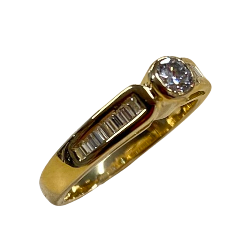 Ladies 18ct Gold 16 Stone Diamond Ring. Single Round Brilliant Cut Rub Over Set, 15 Baguette Cut Diamonds Channel Set In Swept Up Shoulders. TDW 0.50ct. Size K/5.5, With Valuation Certificate – (NG 104625)