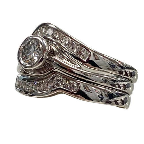 Ladies 18ct White Gold 3 Ring Set. Rub Over Set 0.30ct Round Brilliant Cut Diamond, With 7 Round Brilliant Cut Channel Set In Fitted Bands Each Side. TDW 0.72ct. Size O With Valuation Certificate.