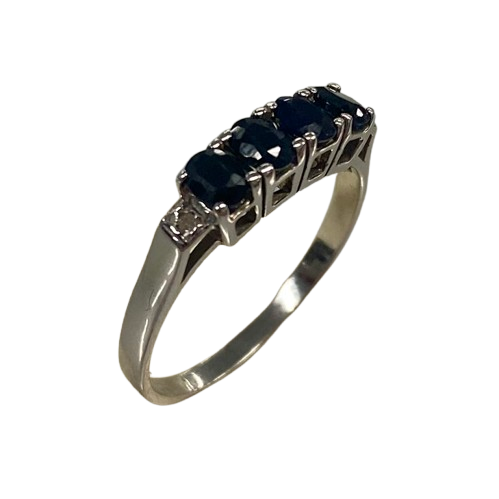 Ladies 9ct White Gold 6 Stone Sapphire & Diamond Ring. 4 Oval Sapphires, 4 Claw Set. With 2 Square Grain Set Diamonds In Swept Up Shoulders. TDW 1.15ct. Size P/8 . With Valuation Certificate – (NG 73254)